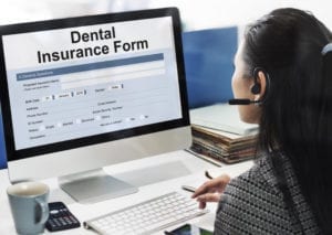 Dental Office Accounts Receivable Require Constant Attention. A Woman Sits At Her Computer Working On A Dental Insurance Claim