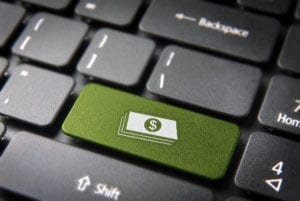 A green key on a keyboard with a dollar sign shows why patient aging reports are important to the dental office.